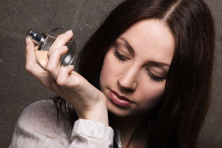 Beautiful lady with a bottle of perfume, face portrait