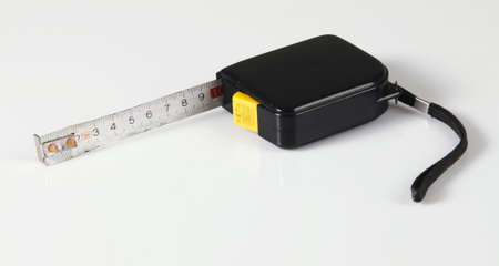 Tape measure on neutral background, closeup photo