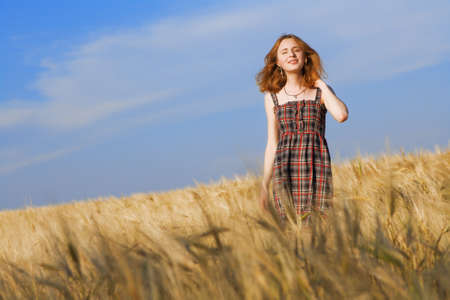 Beautfiul woman in checkered dress in a wheat fieldの写真素材