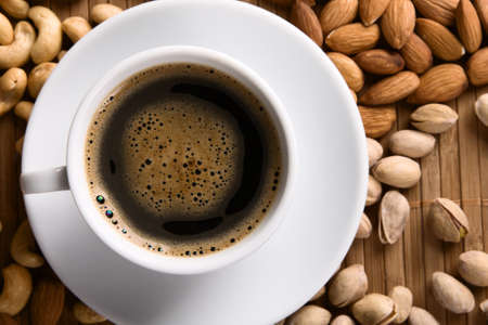 Delicious coffee with nuts on the backgroundの写真素材