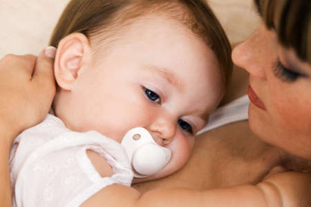 Closeup portrait of a young mother with her little daughter relaxing at home