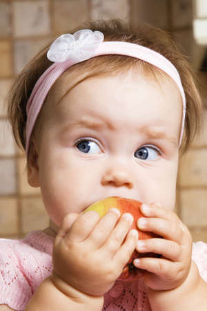 Cute little girl eating an appleの写真素材