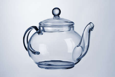 Glass teapot isolated on blueの写真素材