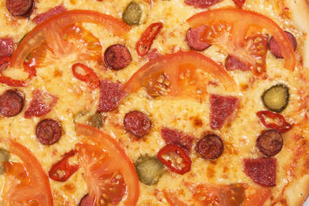 Closeup picture of pizza with tomatoes and pepperoniの写真素材
