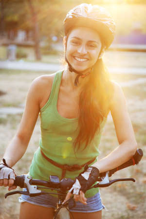 Beautiful young slim woman riding a bicycle