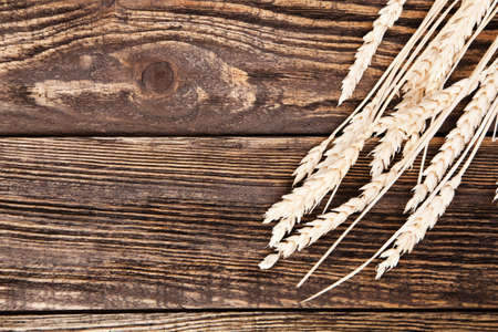 Wheat cones on a wooden tableの写真素材