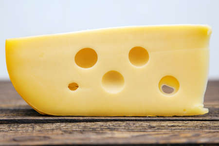 Yellow cheese on a wooden tableの写真素材