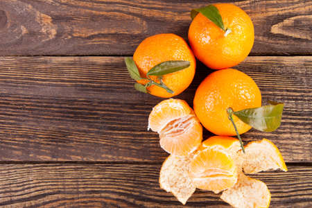 Peeled tangerines on a wooden tableの写真素材