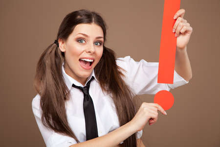 Woman in a schoolgirl costume holding an exclamation makrの写真素材