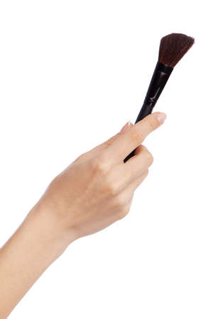 Female hand holding a makeup brush, isolated on white backgroundの写真素材
