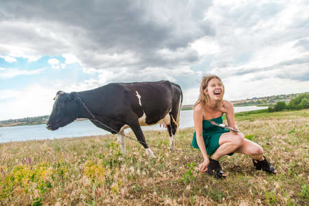 Young woman and a cow in the countysideの写真素材
