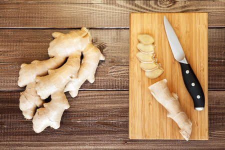 Fresh ginger root sliced on a boardの写真素材
