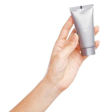 Female hand holding a cream tube, white backgroundの写真素材