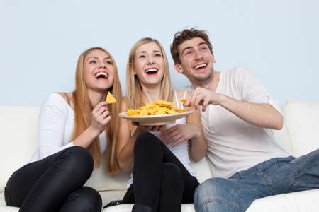 Group of young people eating pizza at home