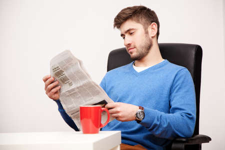 Young man reading a newspaper