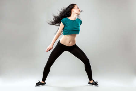 Professional dancer in studio on grey background
