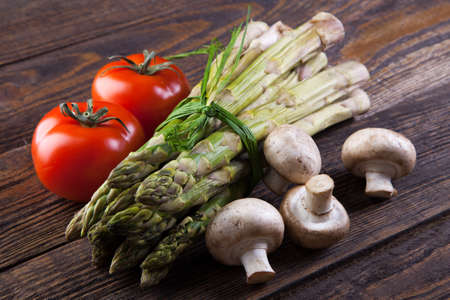 Fresh vegetables and mushrooms on a wooden tableの写真素材