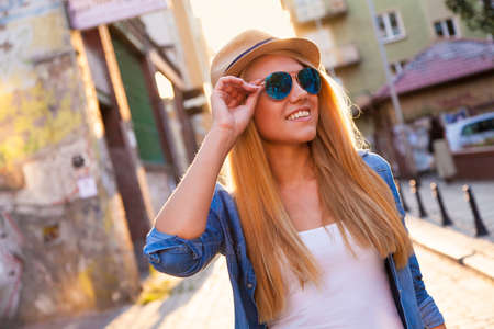 Young stylish woman walking in a city streetの写真素材