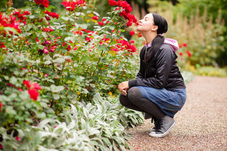 Young woman sniffing roses in a gardenの写真素材