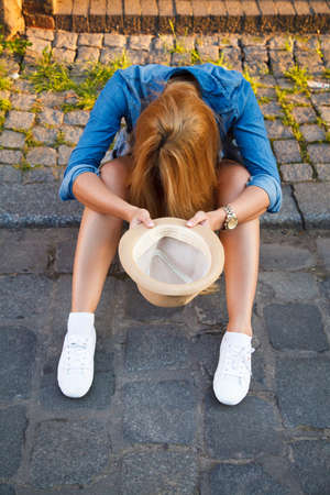Young woman begging with a hatの写真素材