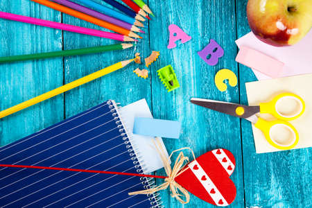 Office and school supplies on wooden surface.
