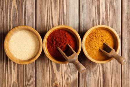 Bowls with spices on wooden tableの写真素材