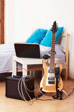 Guitar with an amplifier at home.