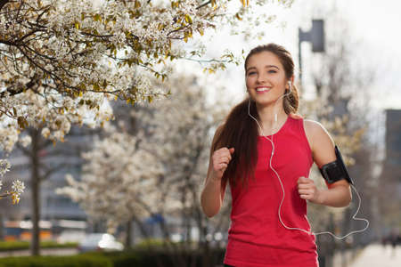 Young beautiful woman running in the city.