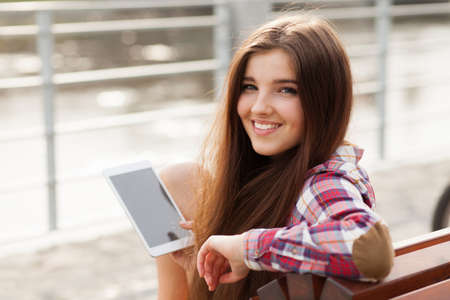 Face portrait of beautiful young woman using a tablet pcの写真素材