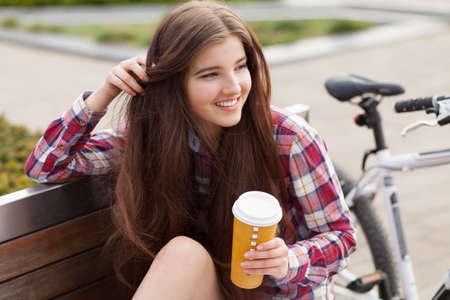 Young woman drinking coffee on a bicycle trip.の写真素材