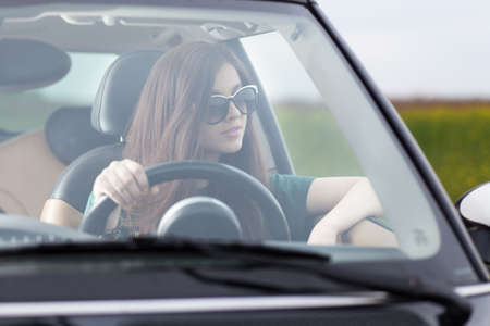 Young beuatiful woman driving a car.