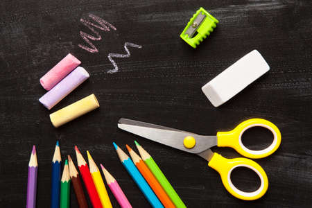 School and office accessories on blackboard surface