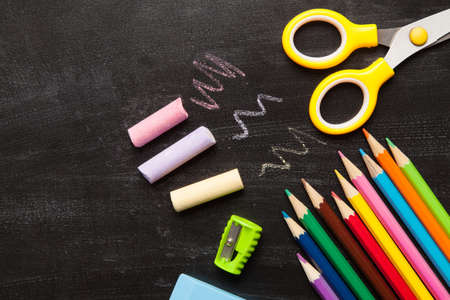 School and office accessories on blackboard surface