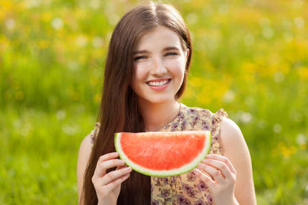 Young beautiful woman eating a watermelon.の写真素材
