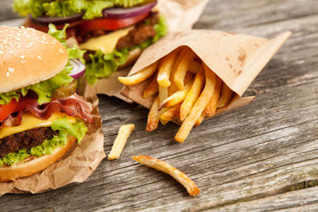 Delicious hamburger and french fries on wooden background