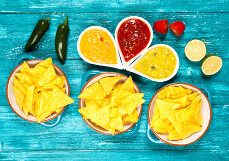 Plate of nachos with salsa, cheese and guacamole dipsの写真素材