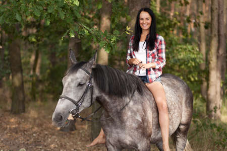 Young beautiful woman with a horseの写真素材