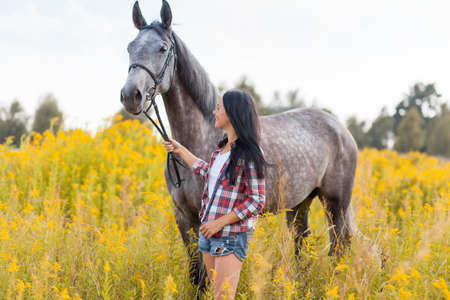 Young beautiful woman with a horseの写真素材