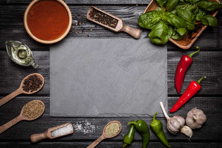 Stone board with different spices on wooden surfaceの写真素材