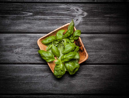 Basil leaves in a wooden bowlの写真素材