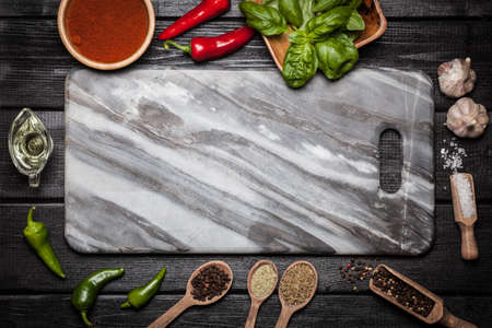 Marble board with different spices on wooden surfaceの写真素材