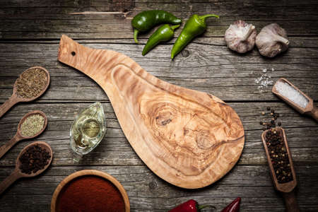 Stone board with different spices on wooden surfaceの写真素材