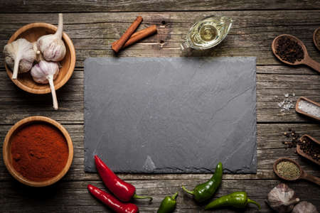 Stone board with different spices on wooden surfaceの写真素材