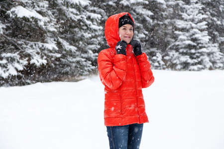 Pretty young woman playing snowballs in the mountains