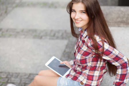 Face portrait of beautiful young woman using a tablet pcの写真素材