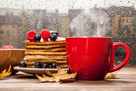 Cup of coffee and pancakes with berriesの写真素材