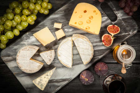 Assortment of cheese with fruits and grapesの写真素材
