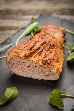 Delicious oven baked pork on a stone boardの写真素材