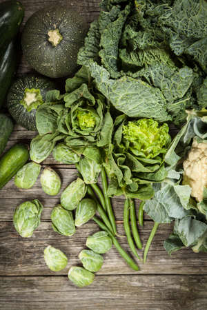 Assortment of green vegetables on wooden surfaceの写真素材
