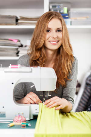 Young woman working with a sewing machineの写真素材